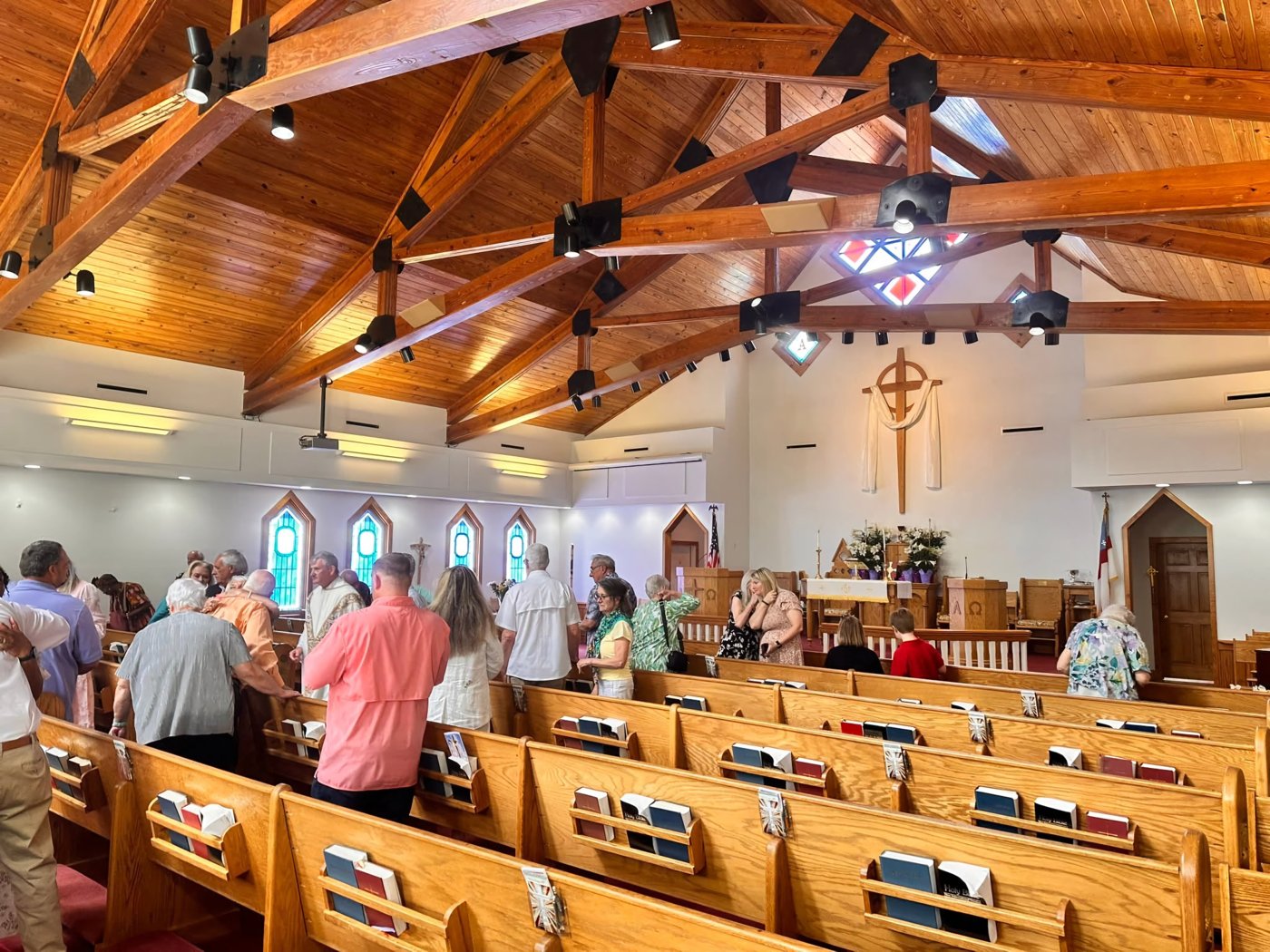 Congregation worshipping beneath the sanctuary wooden ceiling